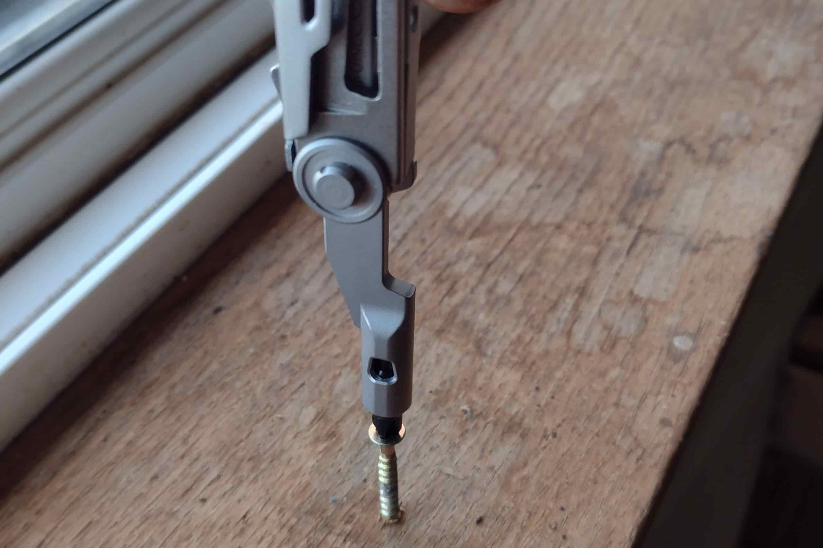 The Gerber Armbar Drive in vertical position screwing a Phillips screw into cedar trim board.