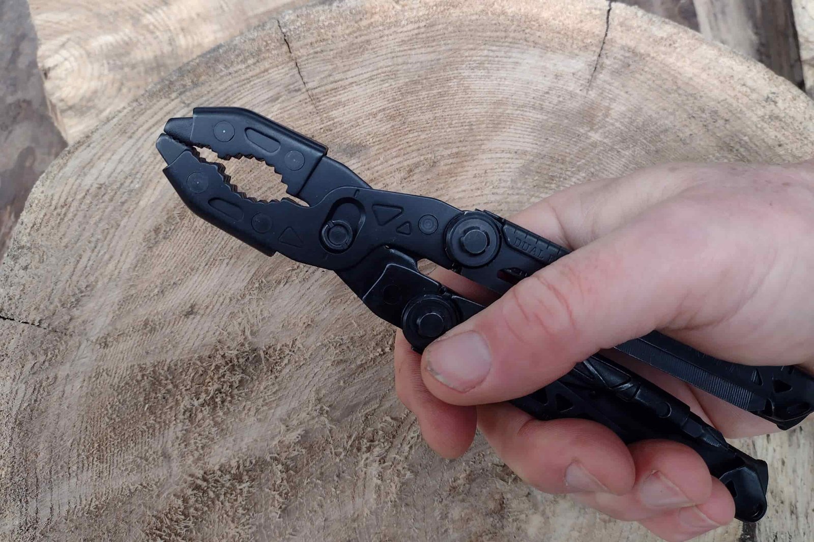 The Gerber Dual Force in hand, held above a log.