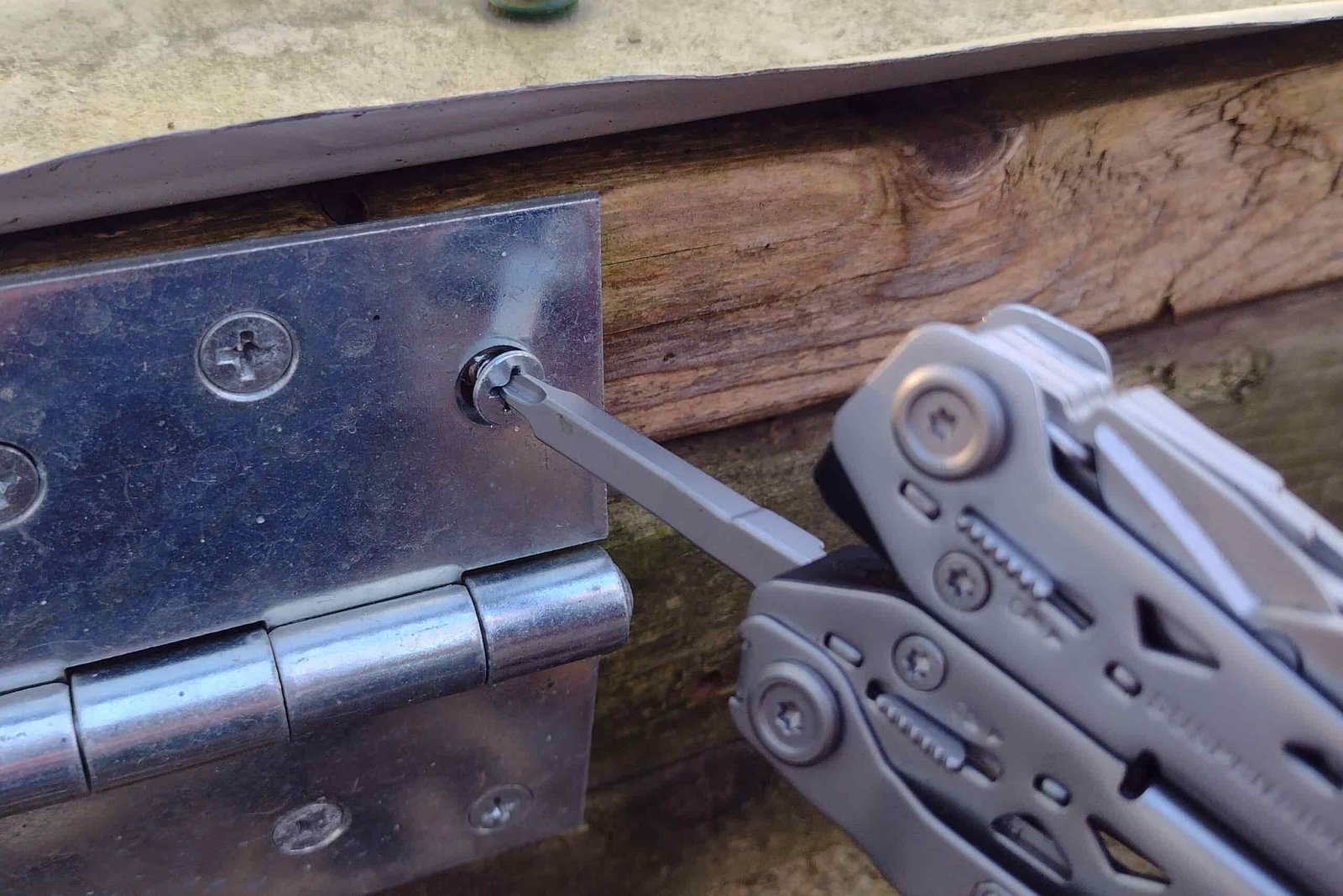 The Gerber Suspension NXT with its Phillips driver extended, turning in a hinge screw.