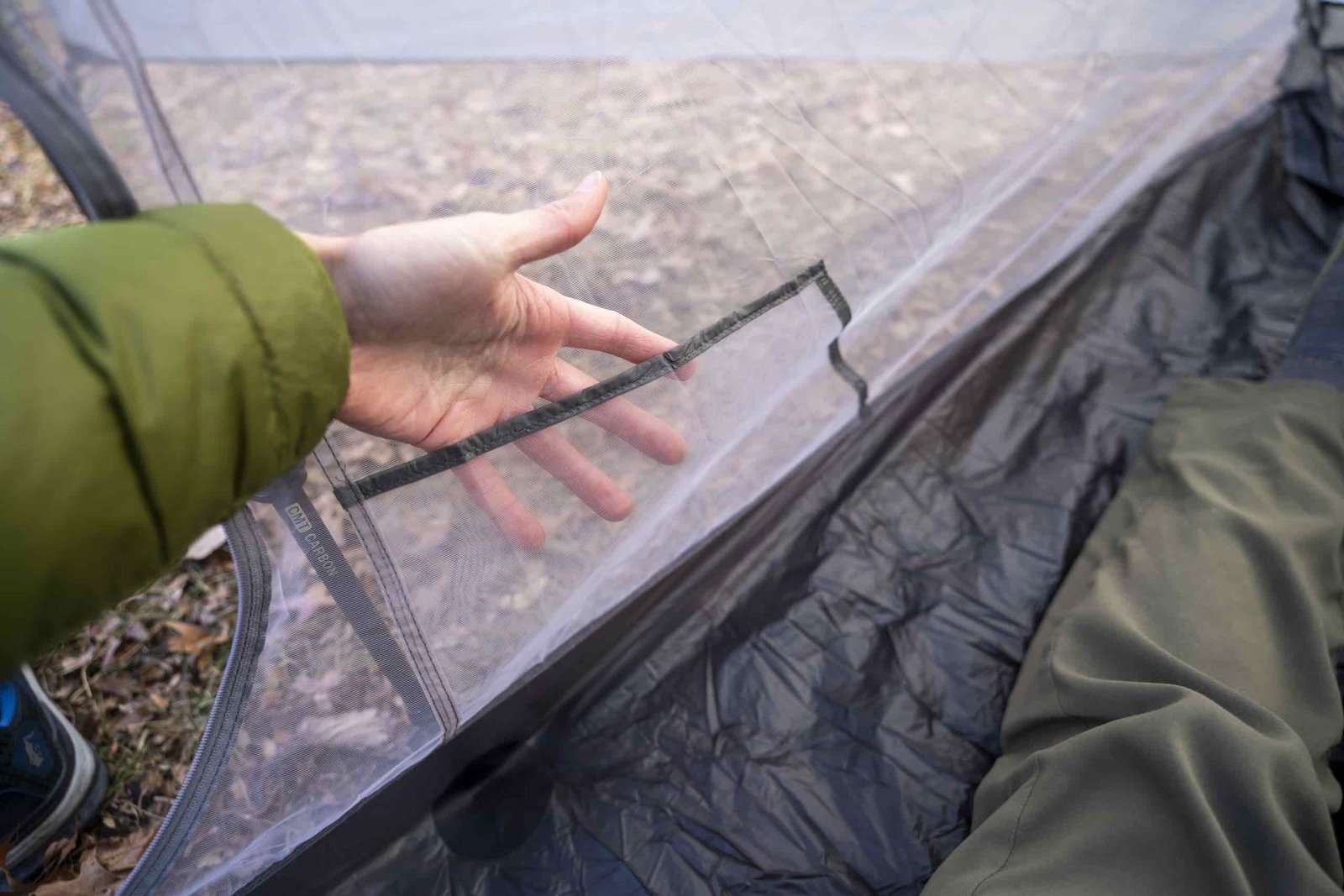 A hand going into a mesh pocket inside a tent
