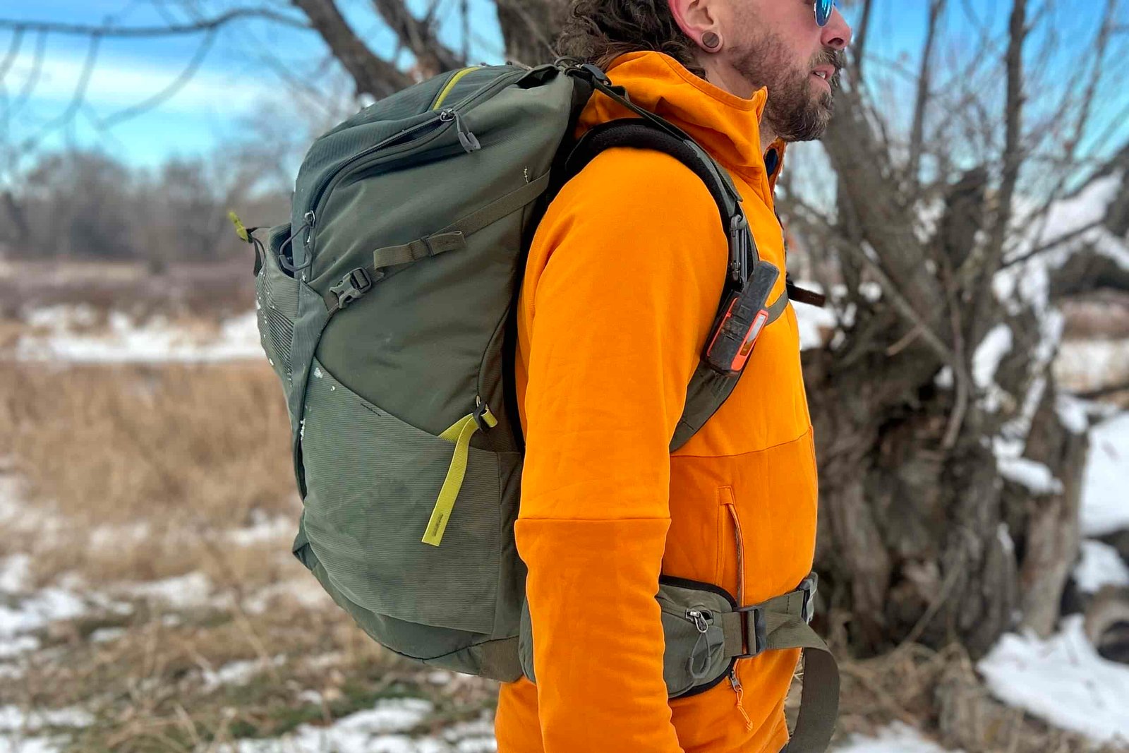 Close up of a man wearing a large daypack from the side.