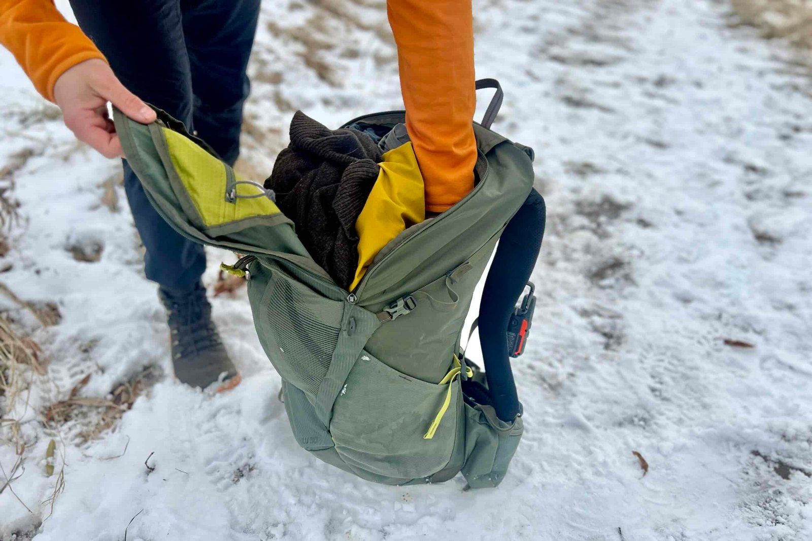 Close up of a person digging through the pockets of their backpack.