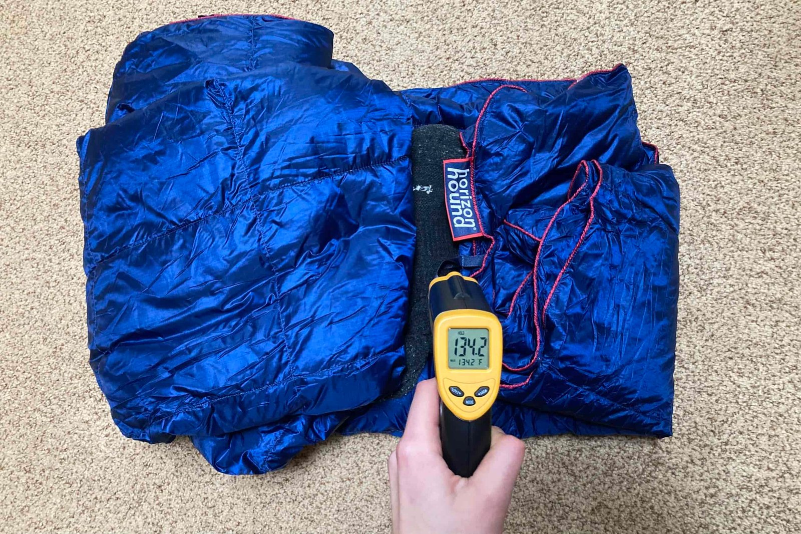 Displaying the reading on the infrared thermometer after the heat sock had been wrapped in the Horizon Hound Trek Blanket for 30 Min. The reading is 134.2F.