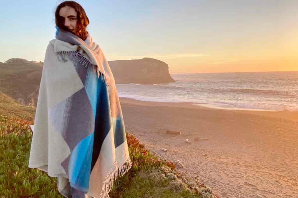 Women wrapped in the Sackcloth and Ashes blanket at the beach