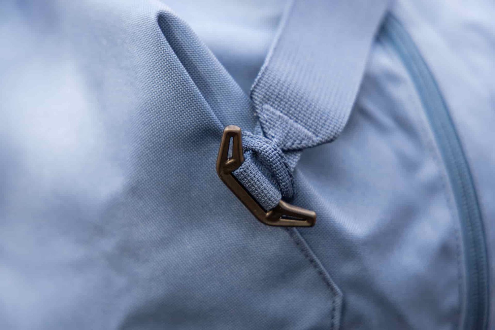 The plastic hook and webbing loop used to attach the removable shoulder strap to the bag.