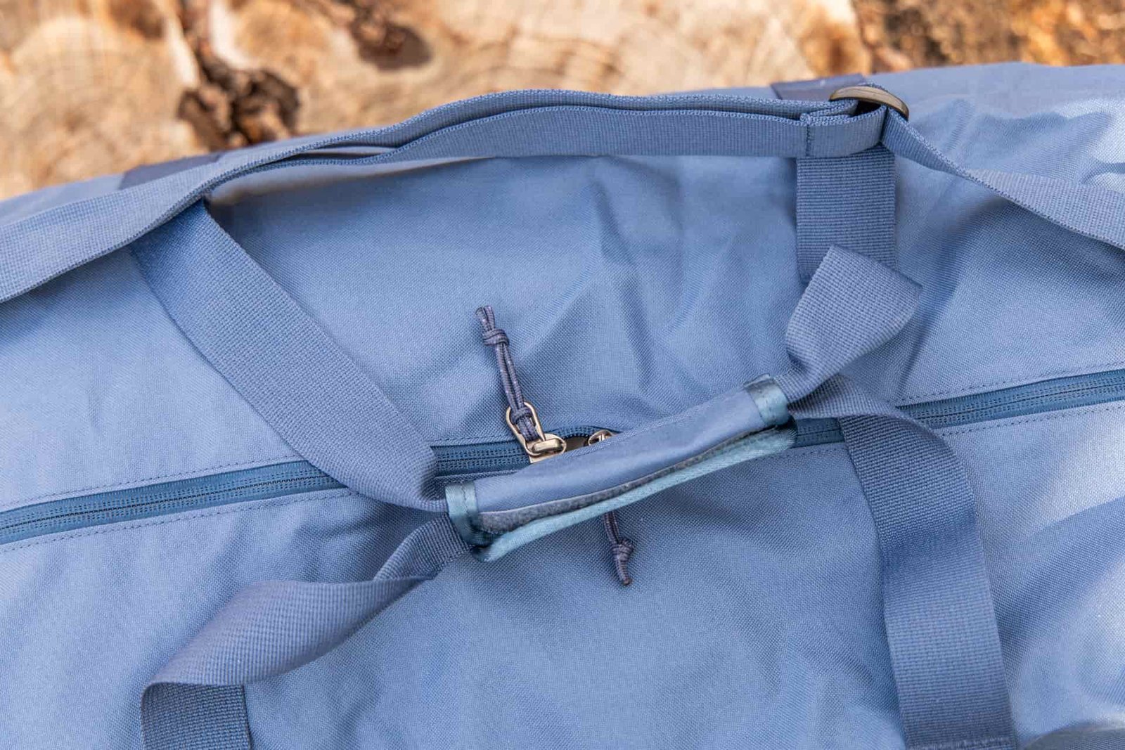 The duffel handles secured together using a velcro handle wrap.