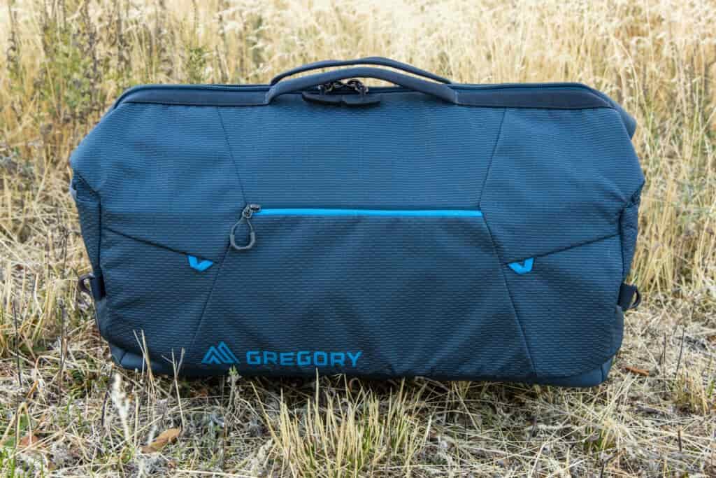 A side view of the Gregory Alpaca Wide Mouth 50 duffel with exterior pocket and top grab handle, but no shoulder strap attached.