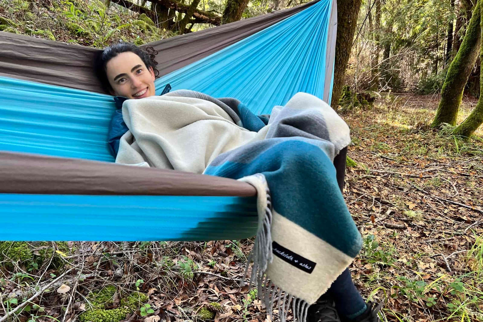 Women laying in a hammock snuggled in the Sackcloth and Ashes blanket.