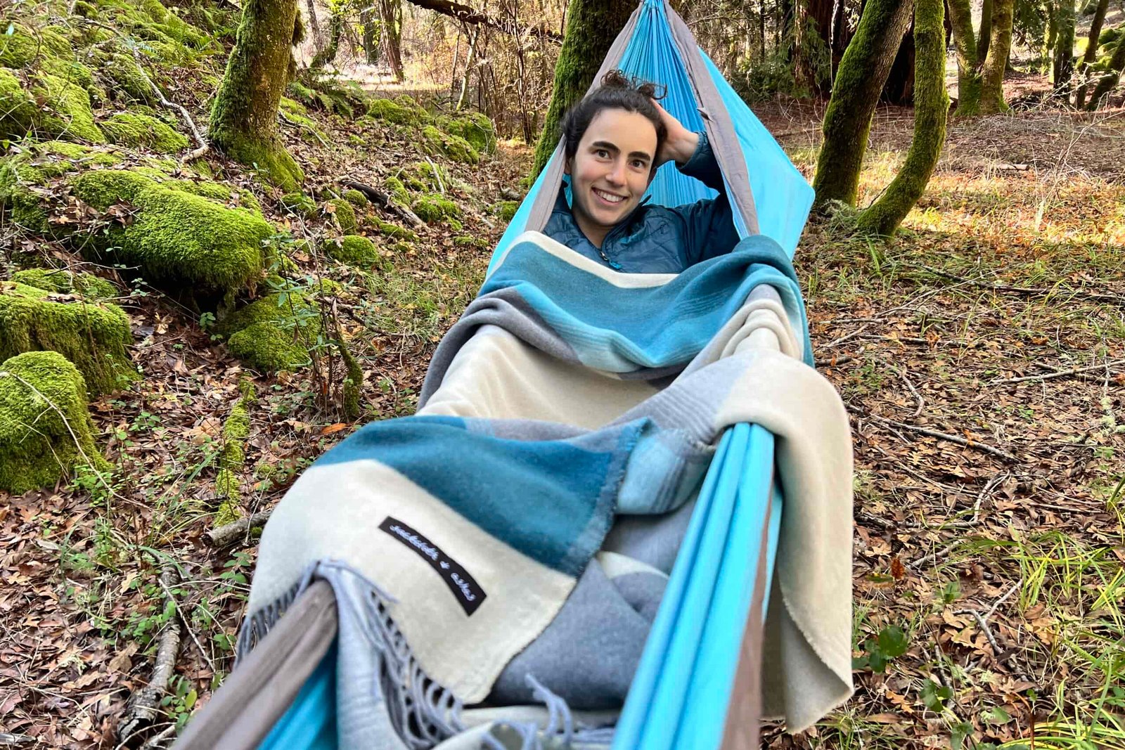 Women laying in a hammock covered with the Sackcloth and Ashes blanket.