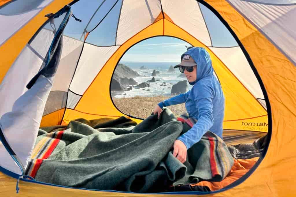 Person in tent laying out the Pendleton Yakima Camp Blanket.