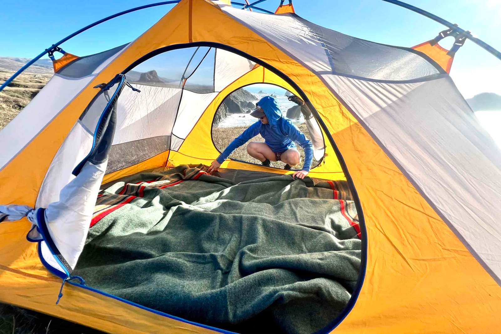 Women laying the Pendleton Yakima Camp Blanket out inside a 2 person tent.
