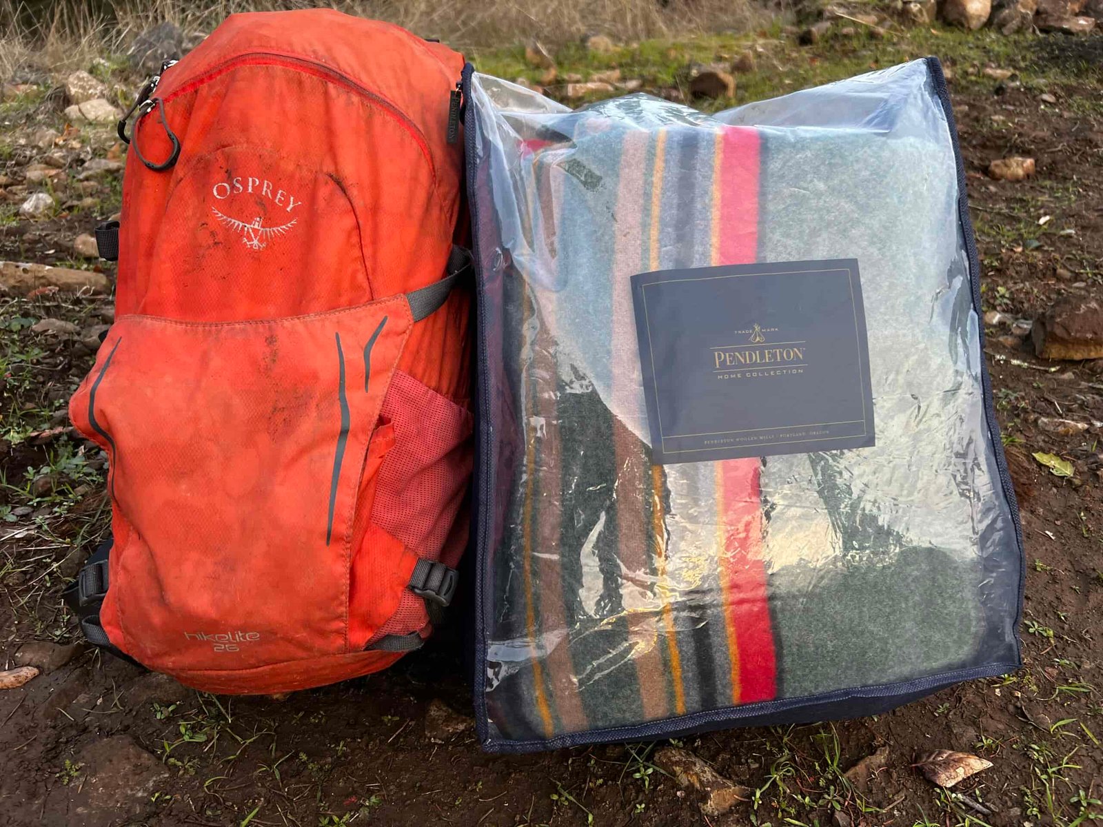 Showing the Pendleton Yakima Camp Blanket size in its plastic case compared to a 26L daypack.