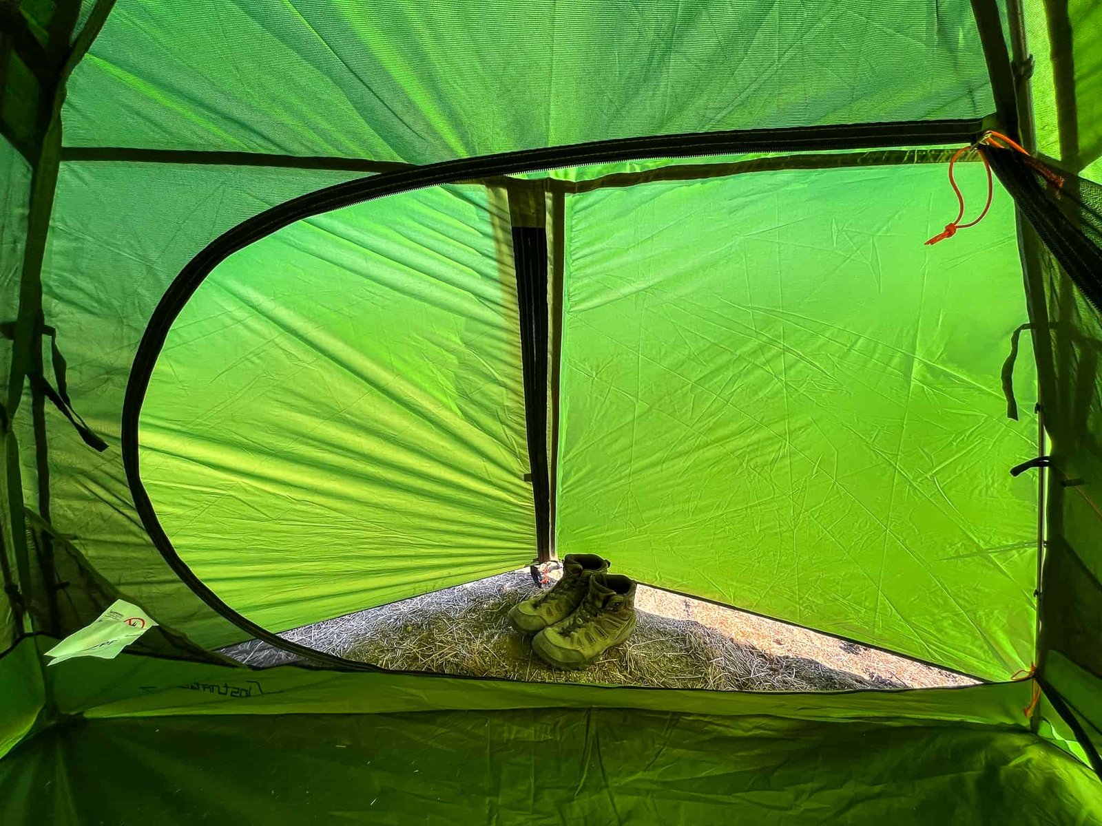 Interior view of the Clostnature Polaris 2 looking out into the fully enclosed vestibule area with a pair of hiking boots.