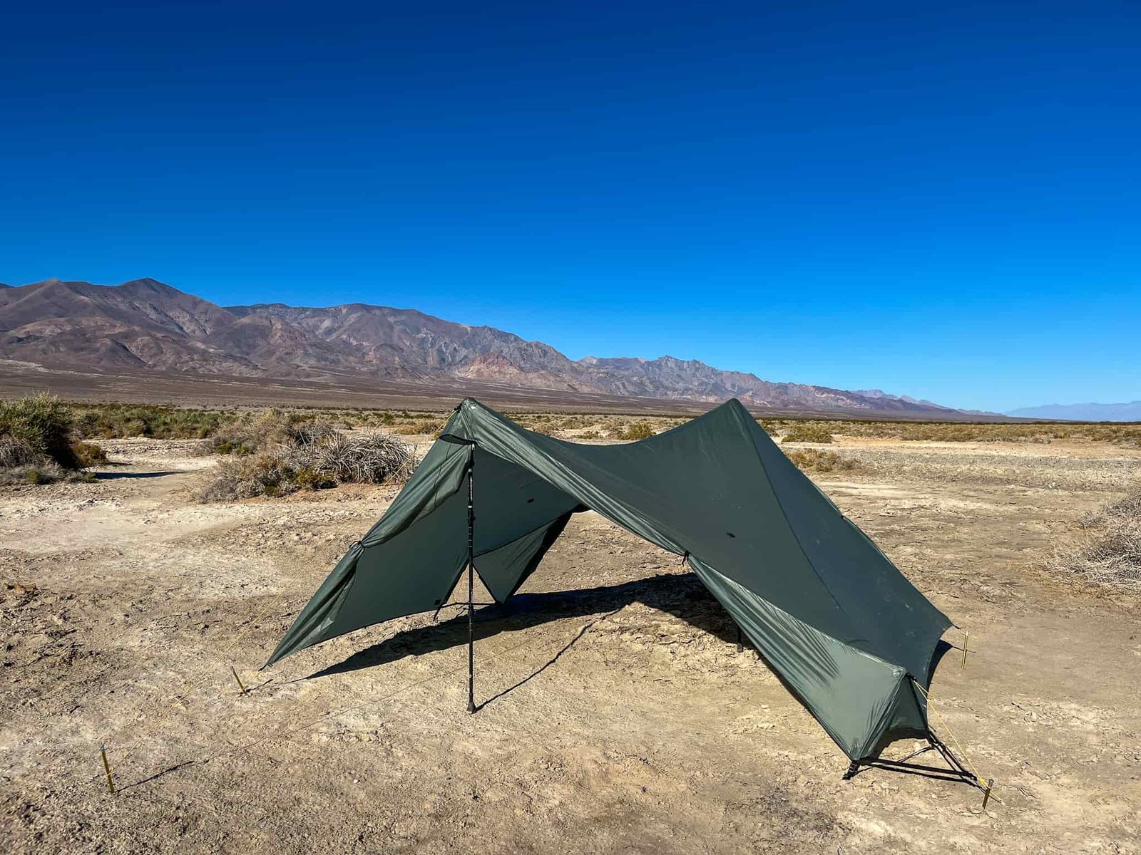 The Tarptent Stratospire 2 pitched with the rainfly only, showcasing minimalist mode or a quick shade shelter. Desert landscape and mountains in the background.