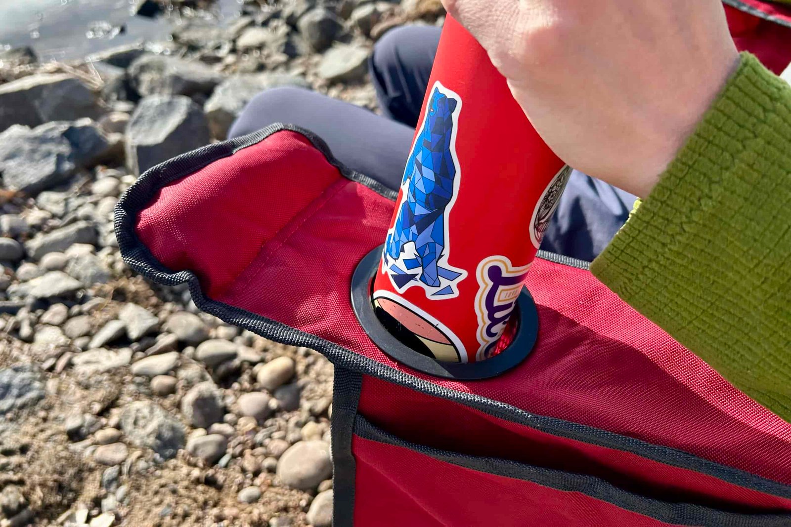 Close up of a person putting a water bottle into a cupholder.