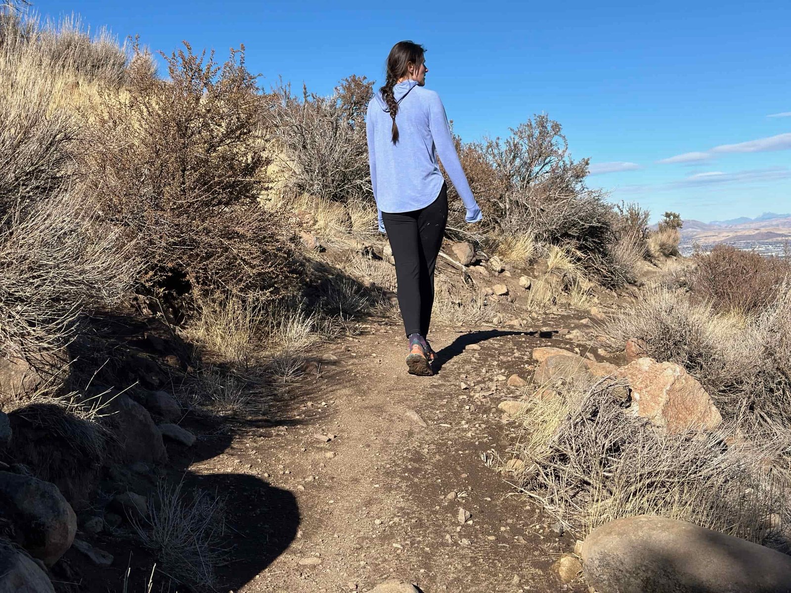 woman hiking in high desert with dog