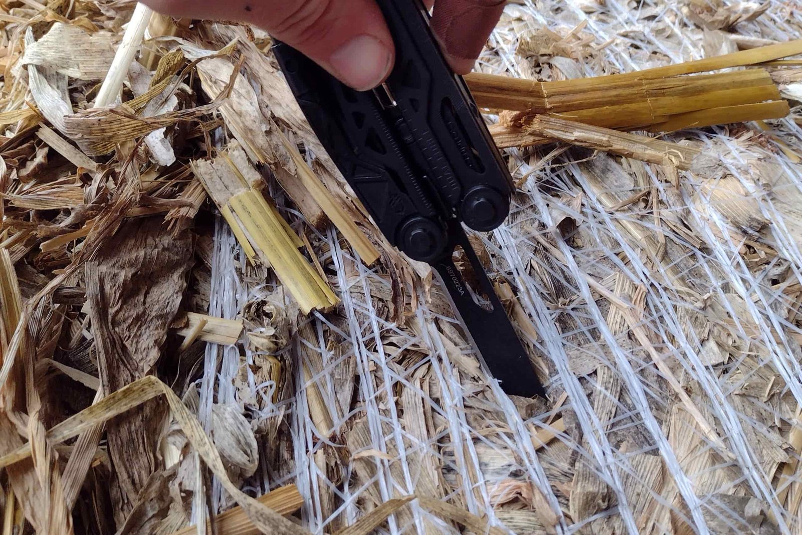 The Gerber Dual Force with its knife blade cutting through hay bale netting.