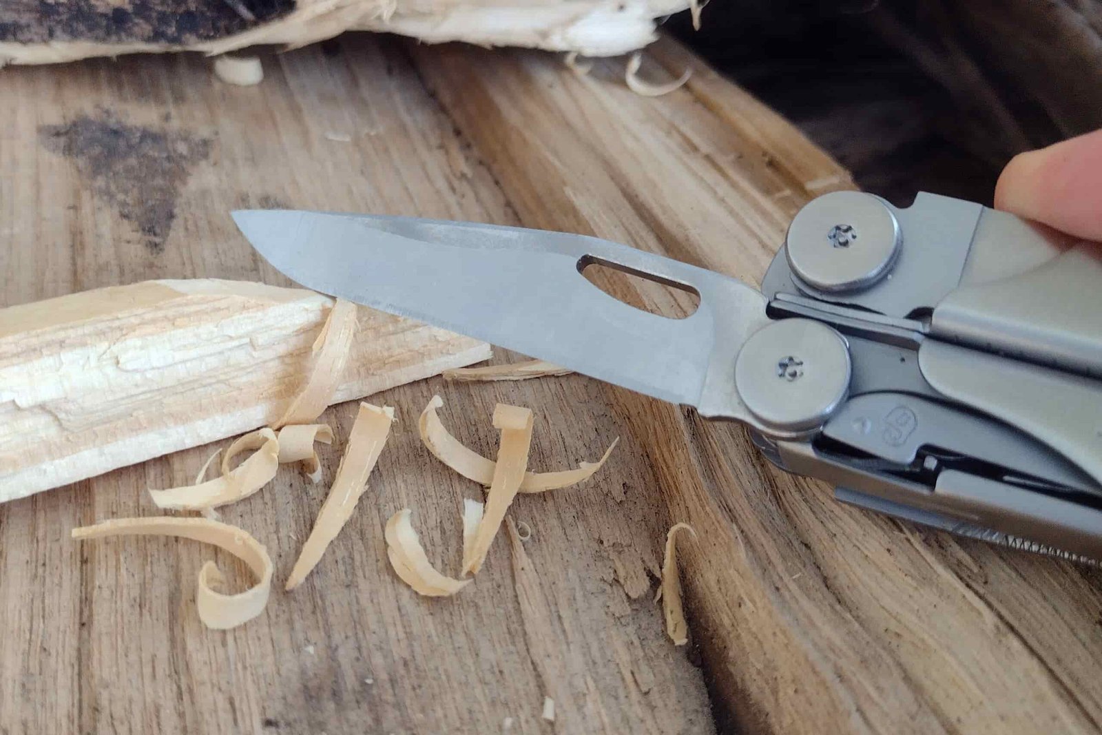 The Leatherman Wave+ with its knife blade extended, cutting wood shavings.