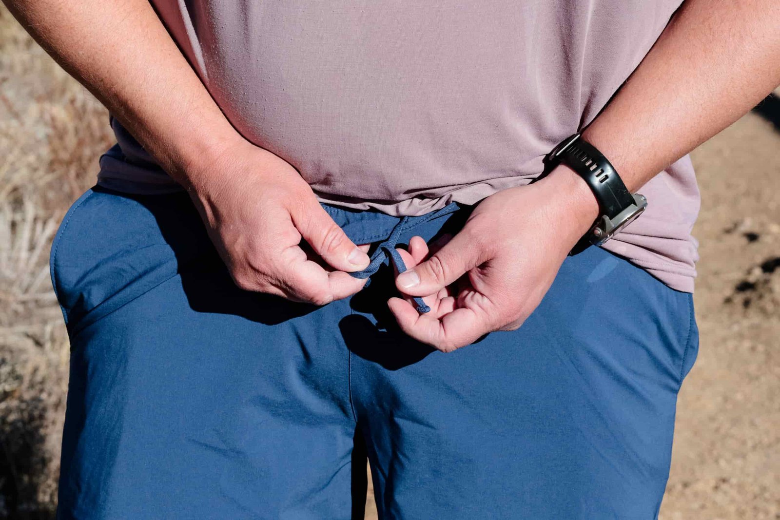 Close up of hands trying a drawstring.
