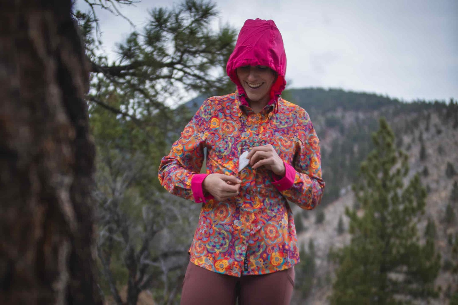 woman hiking with colorful shirt in pine forest