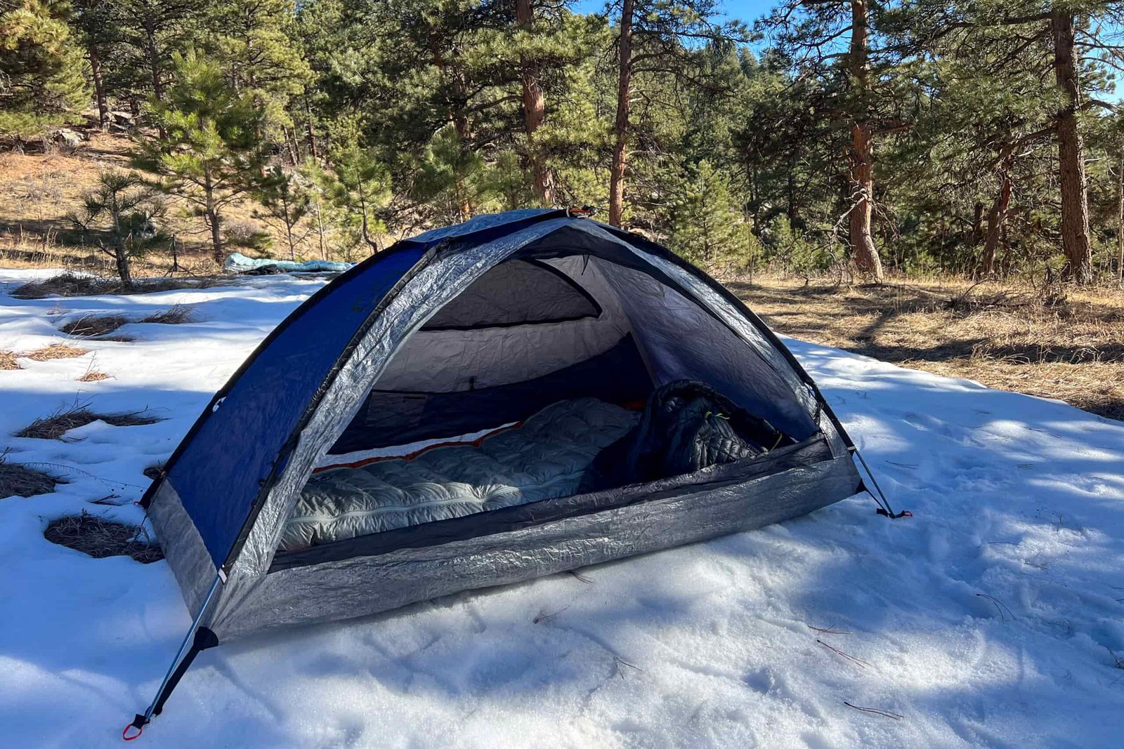 The interior of the Samaya 2.0 tent showing a sleeping bag setup on a snowy surface, with ample headroom and ventilation.