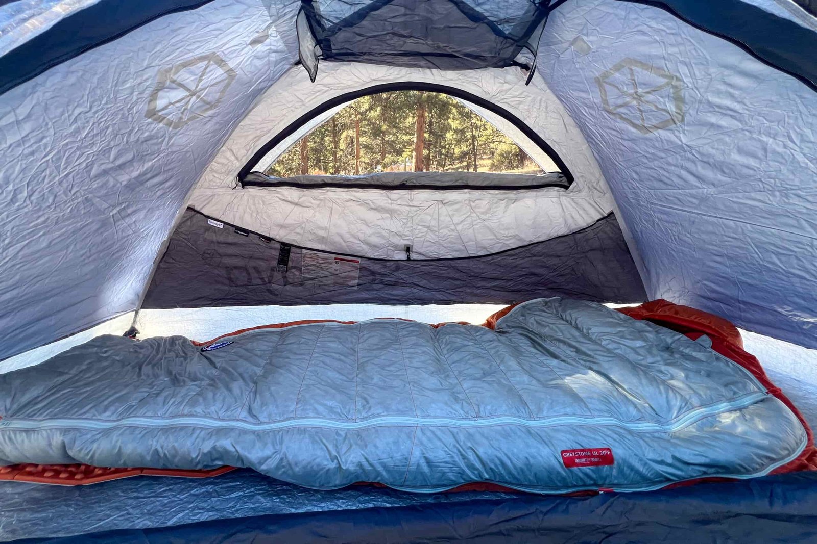 The inside view of the Samaya 2.0 tent, showing one sleeping bag arranged neatly and a large mesh vent on the ceiling for ventilation.