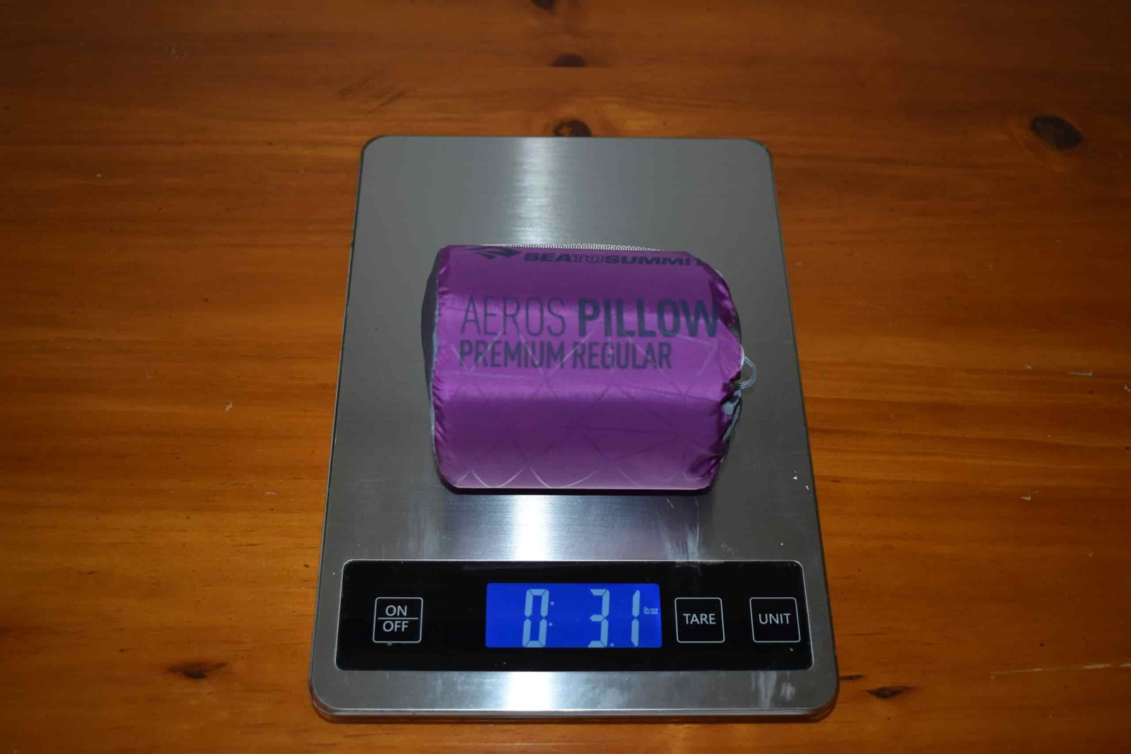Packed pillow sitting on a kitchen scale that displays a weight of 3.1 ounces