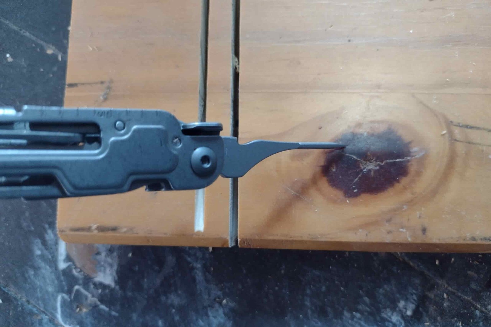 The Gerber Armbar Drive with its awl pointed into a knot on a board.
