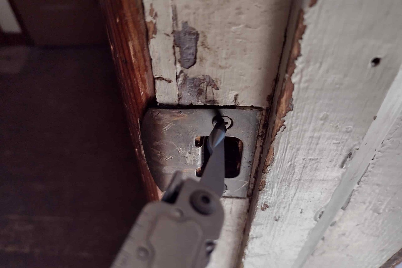 The SOG PowerAccess with its Phillips driver turning in a screw on a door strike plate.