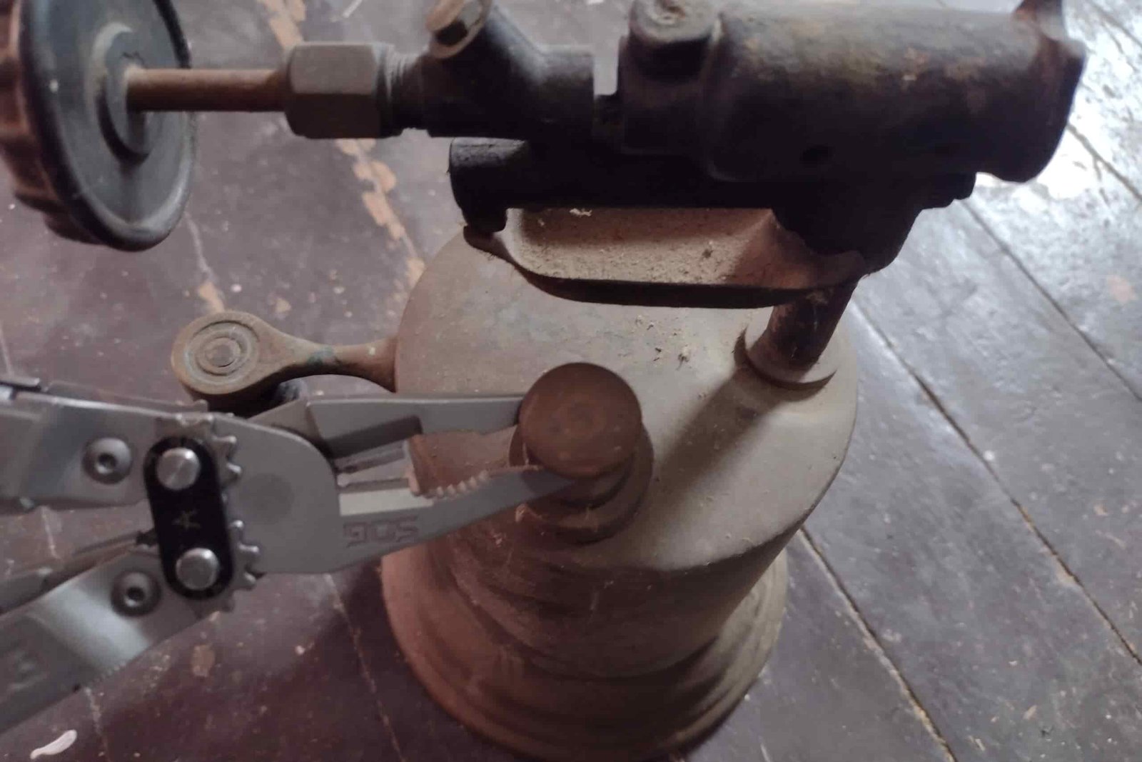 The SOG PowerAccess Deluxe adjusting an old torch with its pliers.