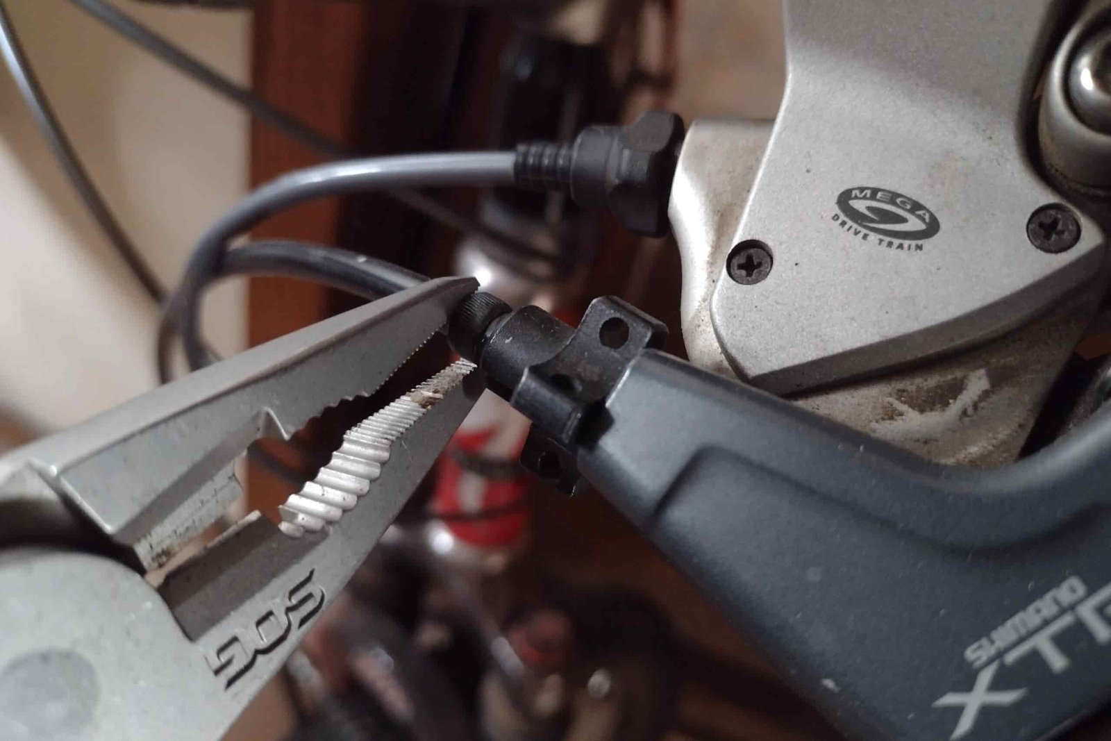 The SOG PowerAccess Deluxe adjusting a bicycle brake cable with its pliers.
