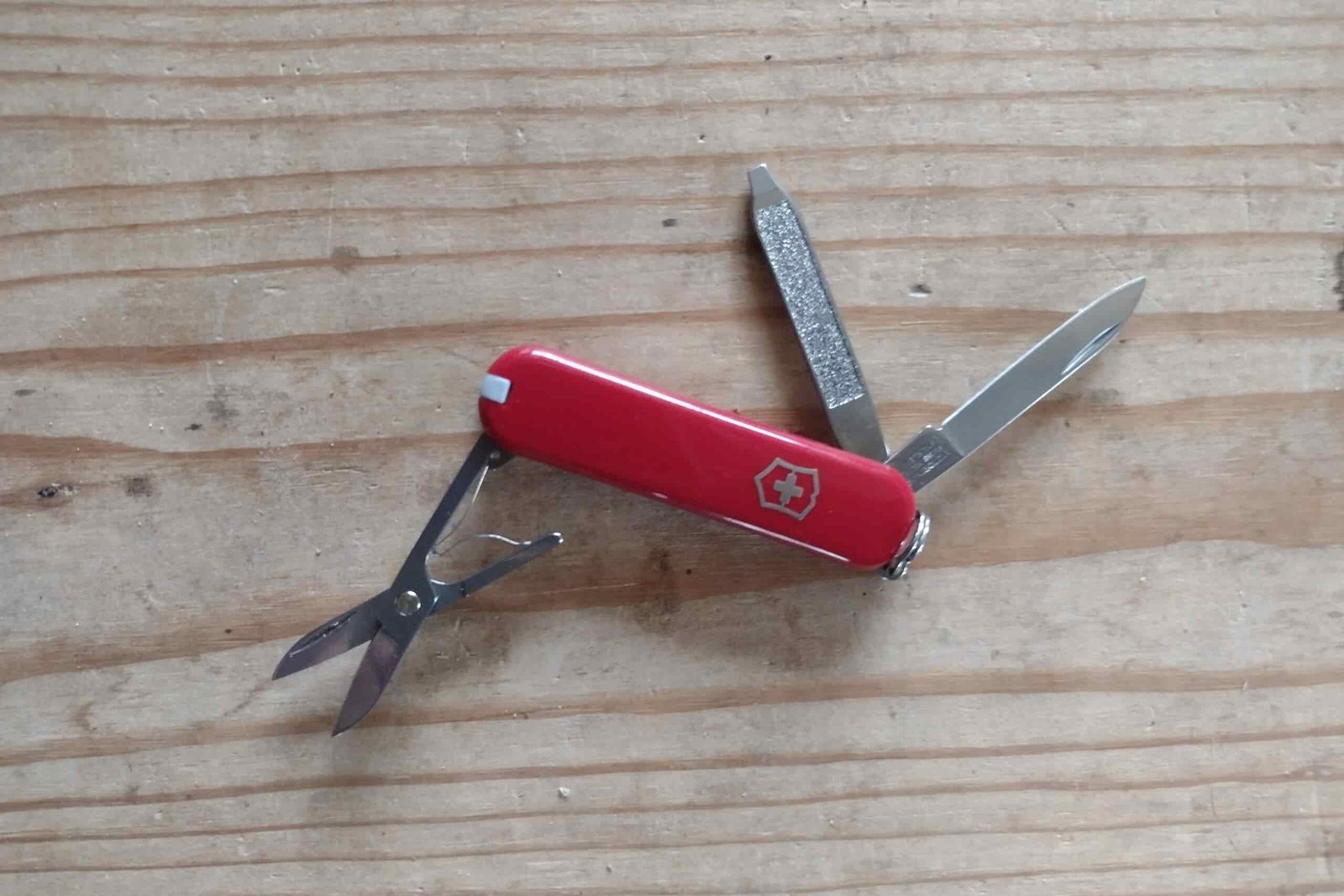The Victorinox Classic SD resting on a board, with its tools deployed.