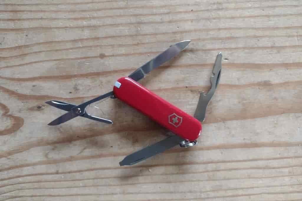 The Victorinox Rambler, resting on a board, with its tools deployed.