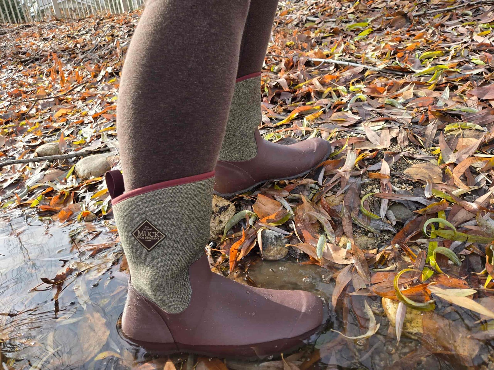 Side view of the Muckster II rain boot as someone steps out of a puddle.