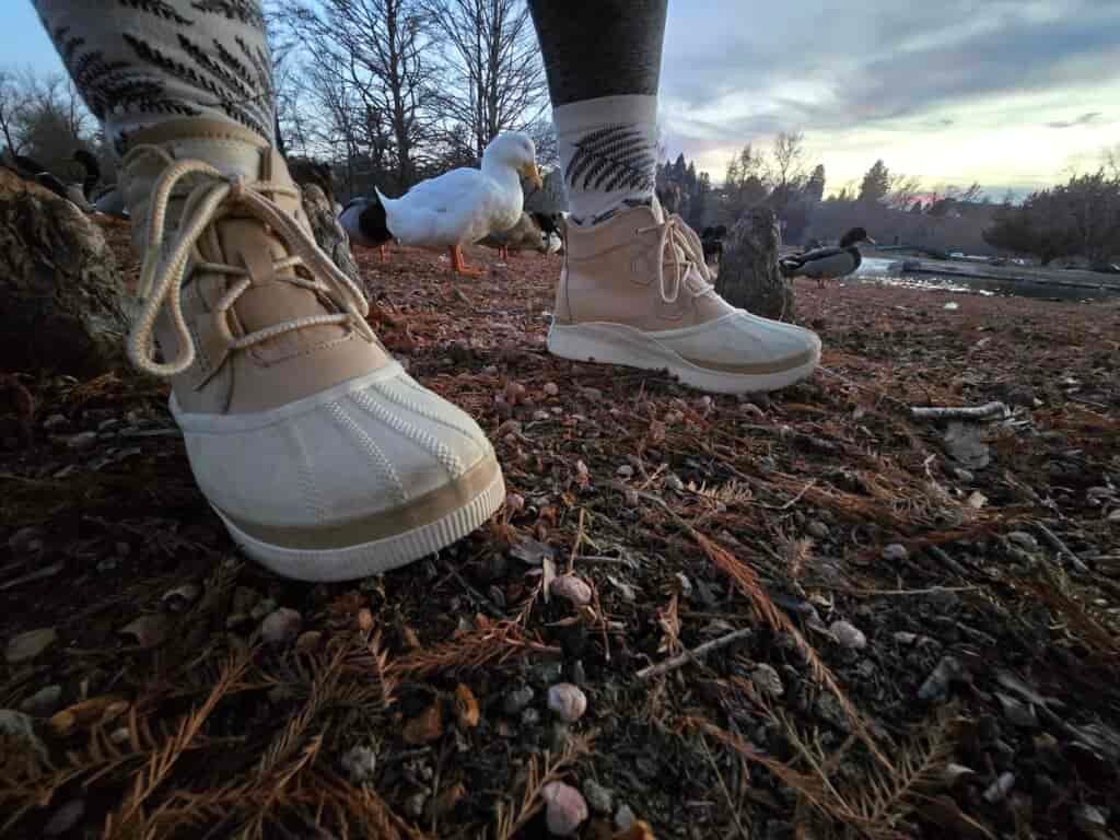 a woman wearing the sorel out-n-about IV's on bare ground