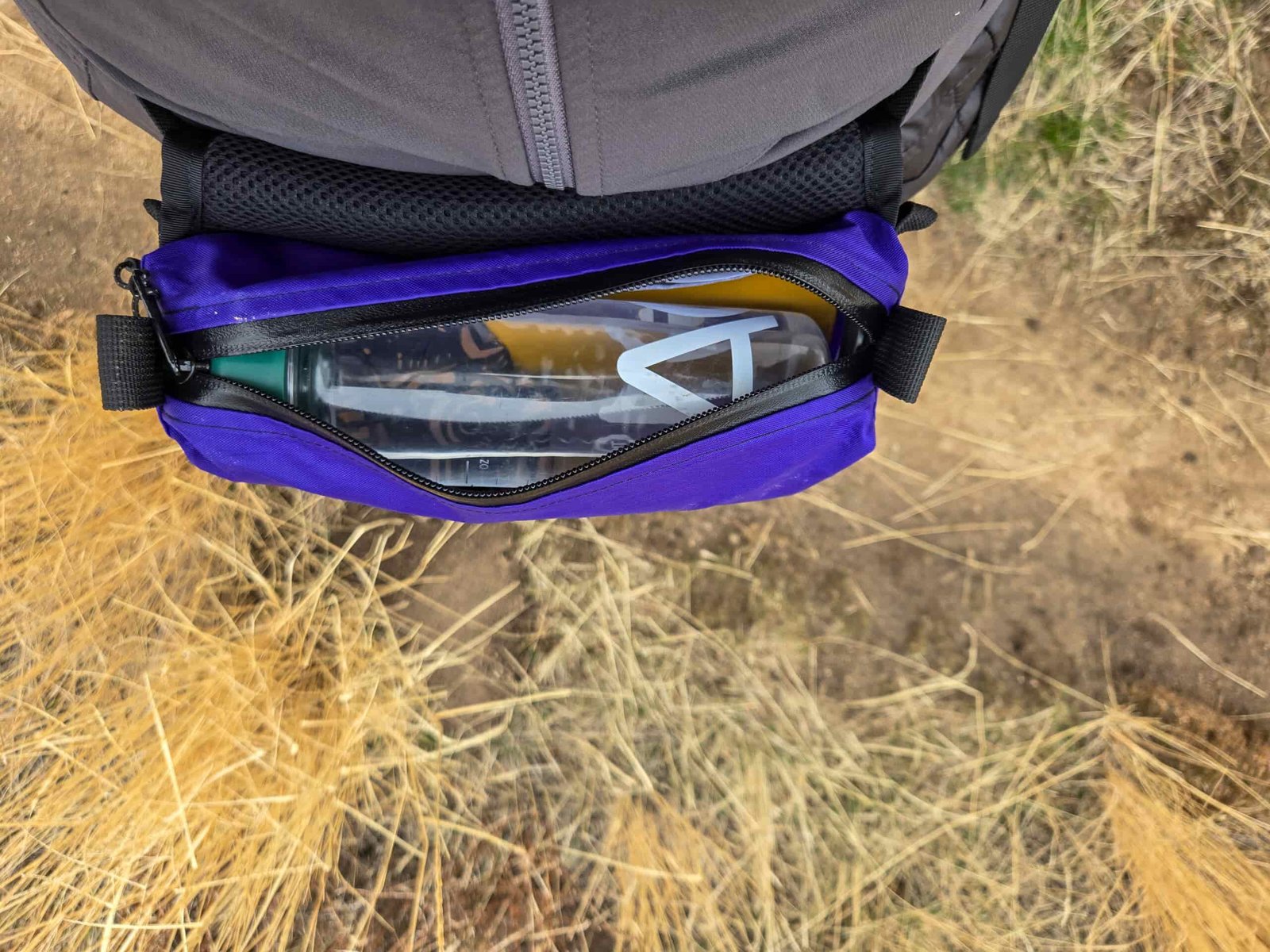 a view of someone wearing a thrupack summit bum fanny pack with it fully packed and unzipped on their waist