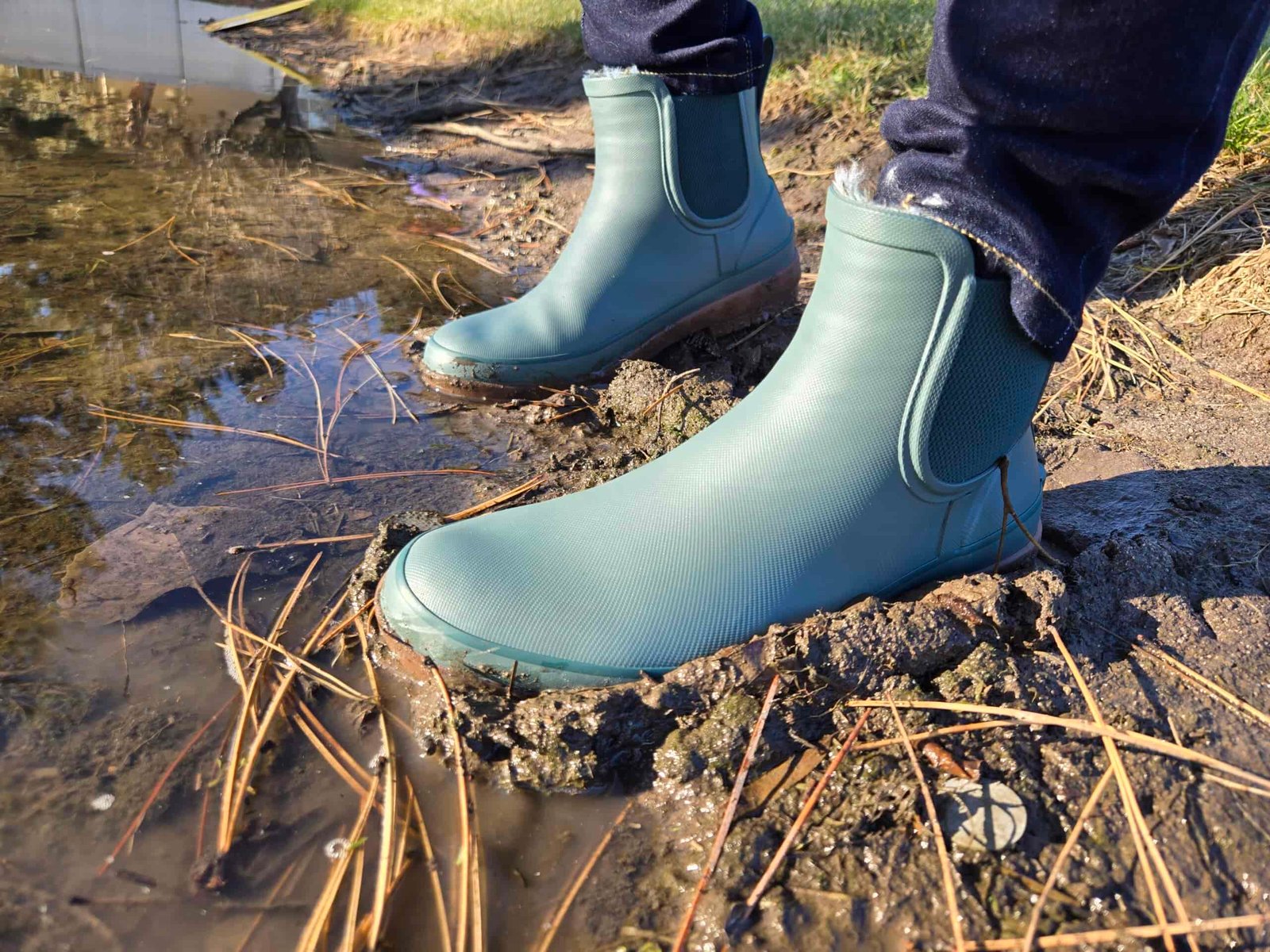 a view of someone walking in the mud wearing bogs amanda chelsea rain boots