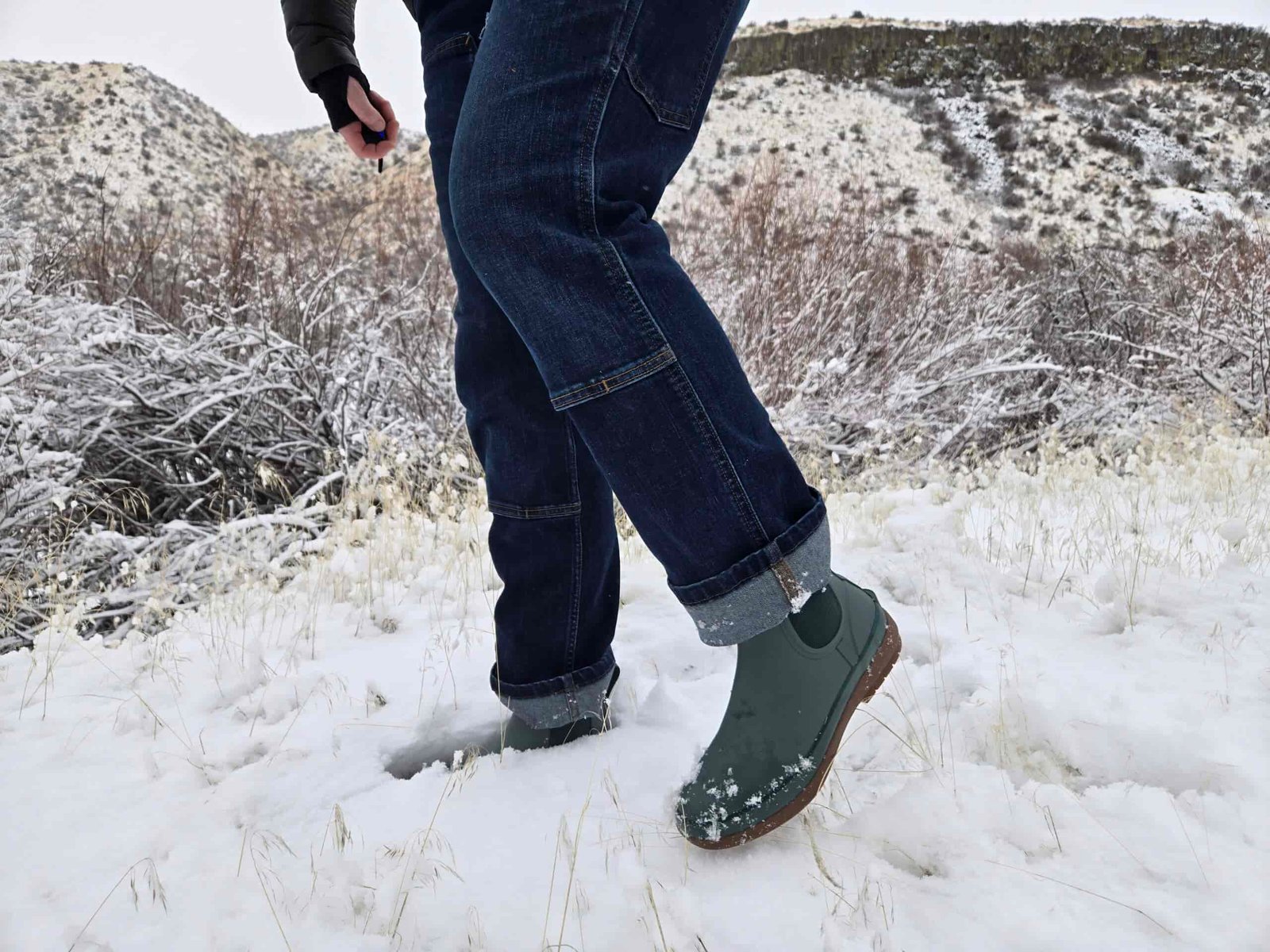 view of a woman's legs wearing the bogs amanda chelsea boot in some light snow