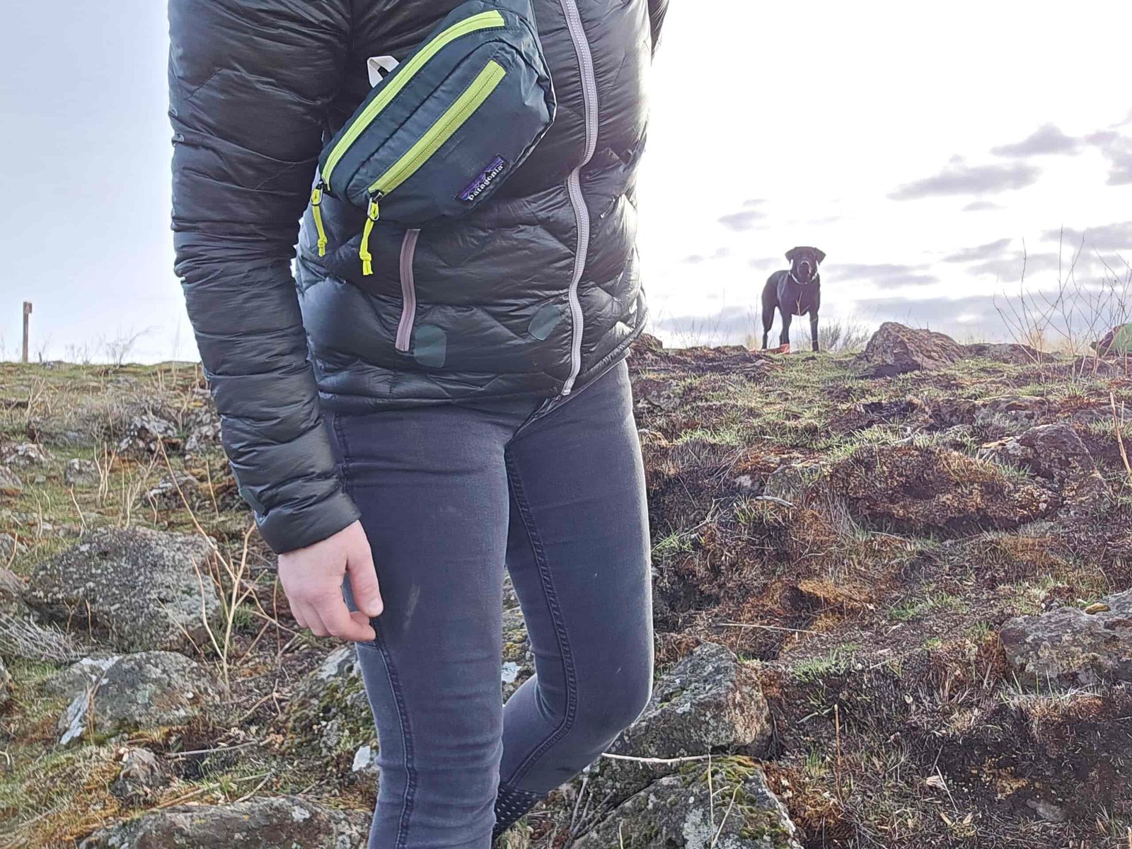 woman wearing the patagonia black hole mini hip pack as a shoulder sling