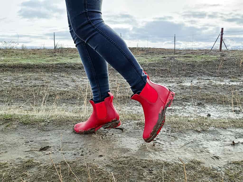 woman on a farm walking in mud in ankle rain boots by asgard