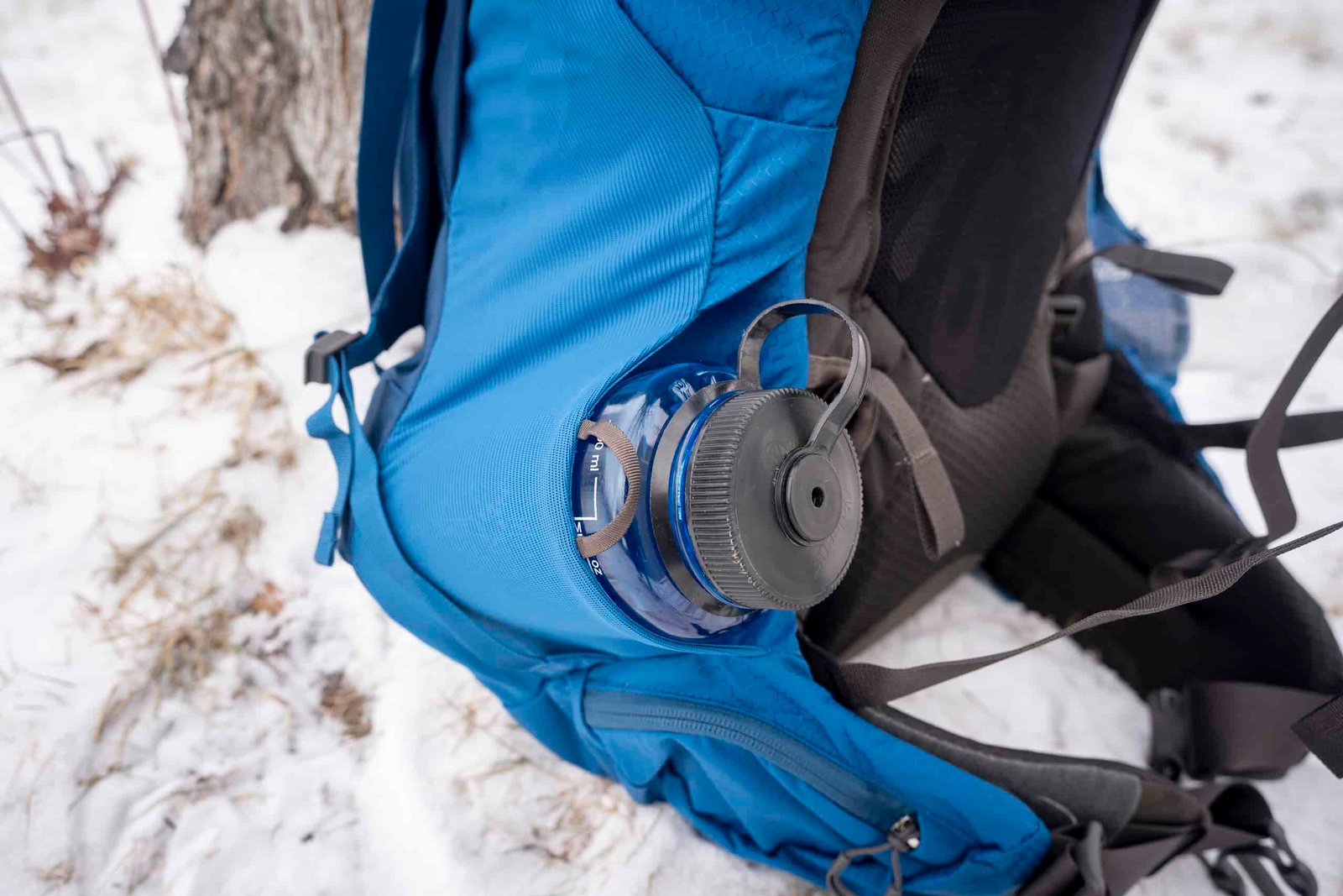 water bottle in side pocket of blue backpack