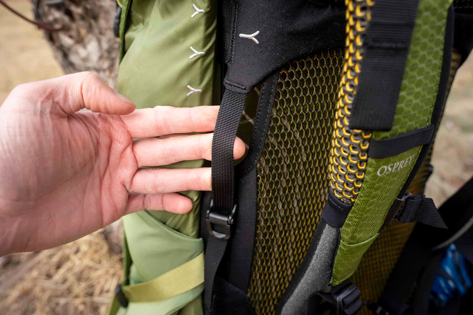 hand holds adjustment strap on backpack