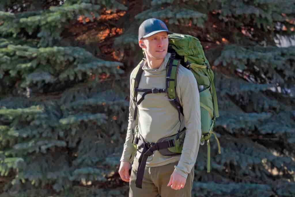 man wears a green backpack