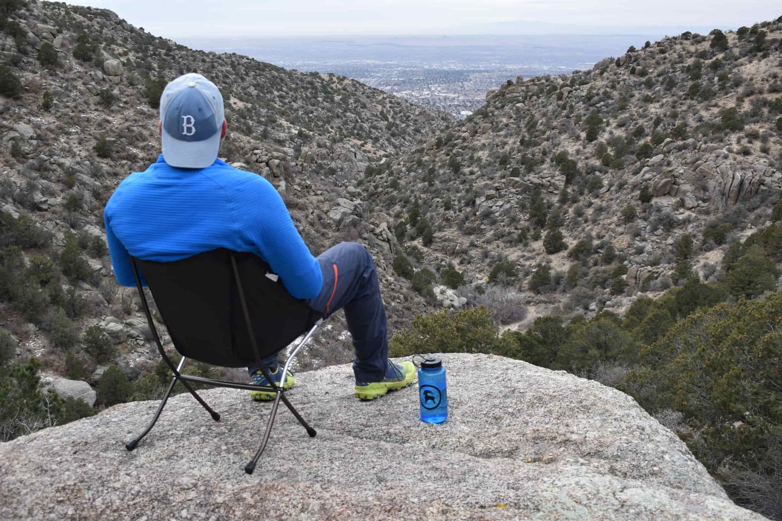 Hiker sitting on the Big Agnes chair in the foreground with a 50 mile view in the background of the New Mexico desert