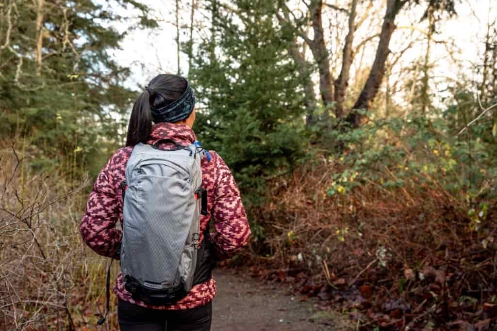 Details of CamelBak H.A.W.G. Pro 20 100oz - showing a person wearing a jacket and the pack in nature