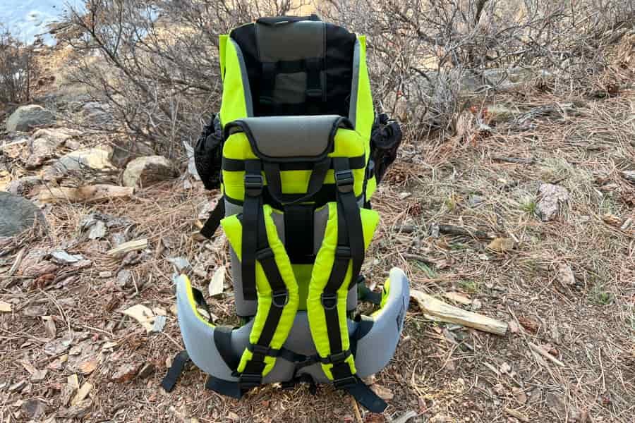 Rear view of the child carrier showcasing the bright green design and padded straps for support.