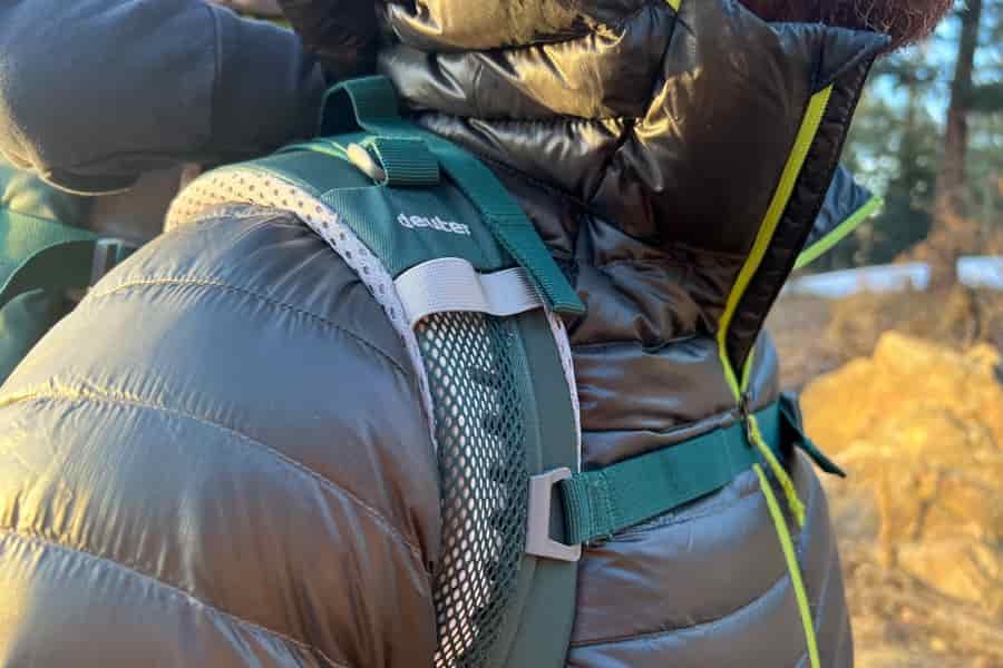 A close-up of the shoulder strap area of the Deuter Kid Comfort carrier, showcasing the breathable mesh and secure attachment points.