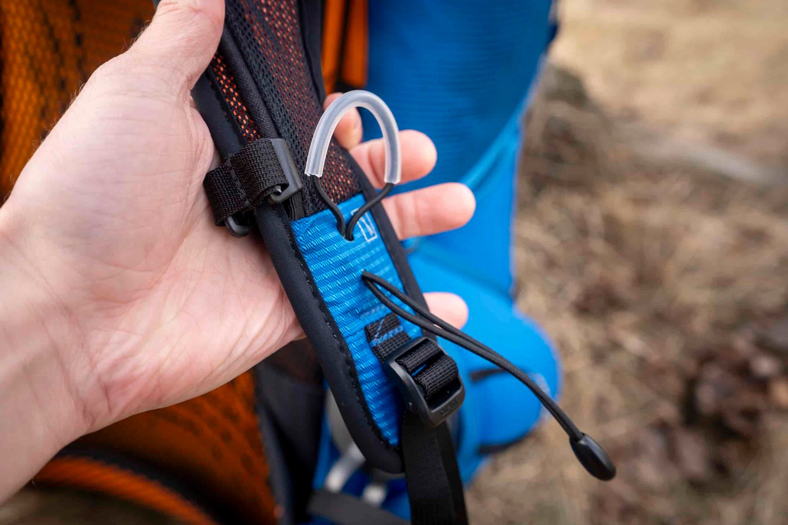 a hand holds a backpack strap
