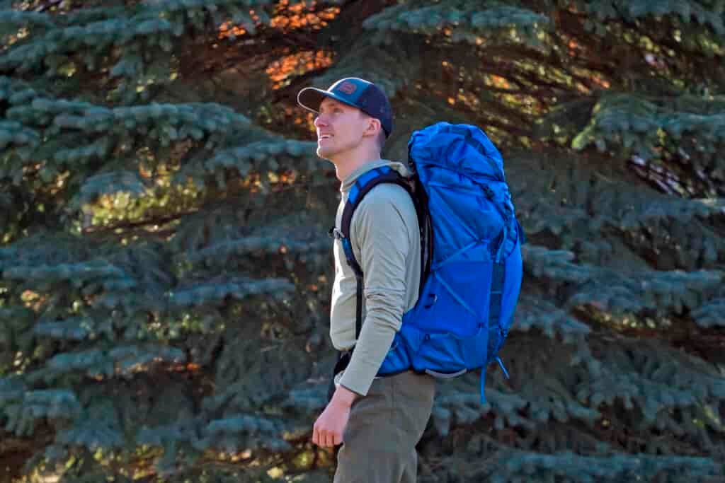 a man wears a blue backpack