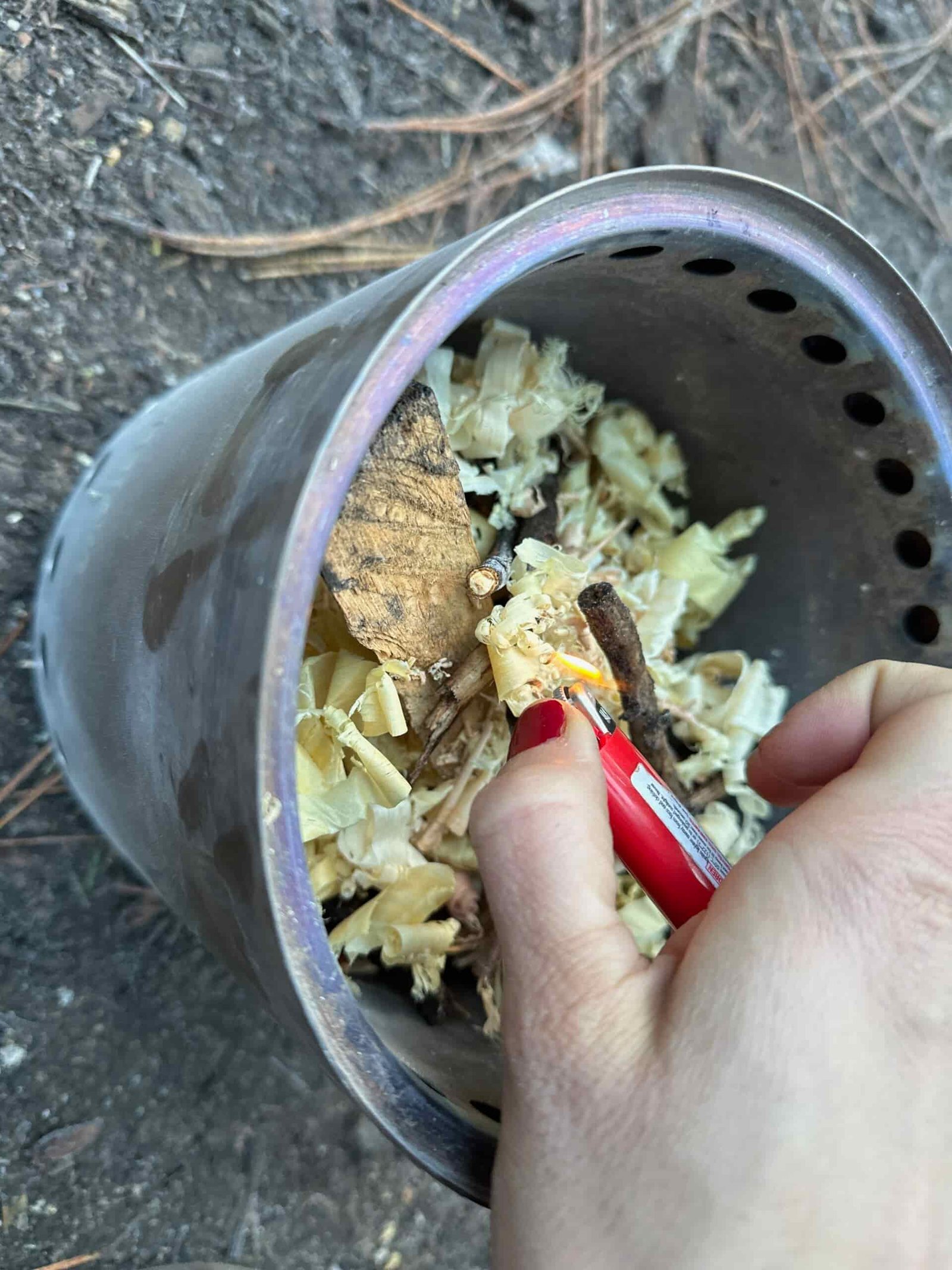 filling the Solo Stove Campfire with fuel (like twigs and wood shavings) and lighting the stove. 